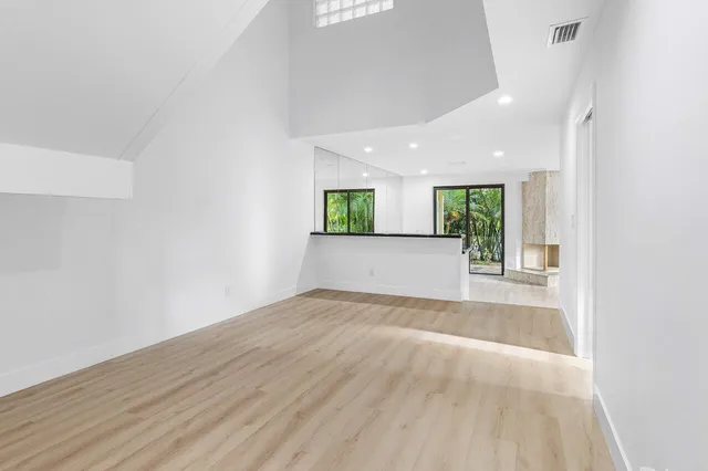 a view of a hallway with wooden floor and entryway