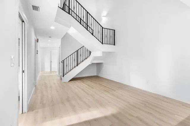 a view of an empty room with windows and a fireplace
