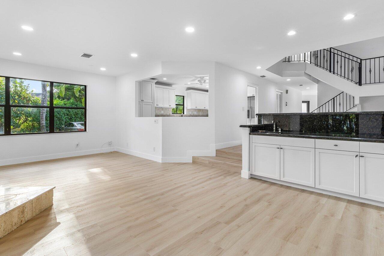 5109 North Ocean Boulevard, Unit H Ocean Ridge, FL 33435 - Photo 9 of 45 a large white kitchen with a large window a refrigerator and wooden floor