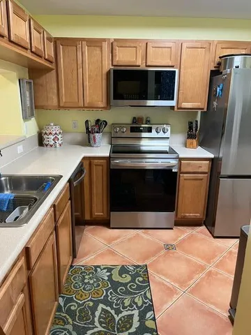 a kitchen with stainless steel appliances a stove a sink and a microwave