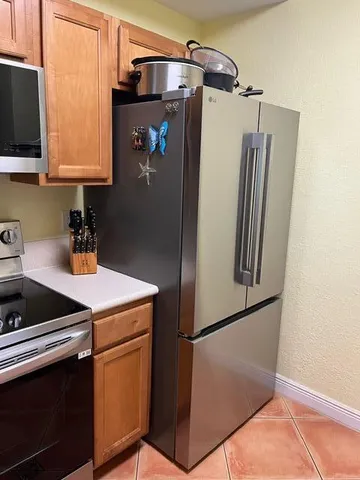 a kitchen with stainless steel appliances a refrigerator sink and microwave