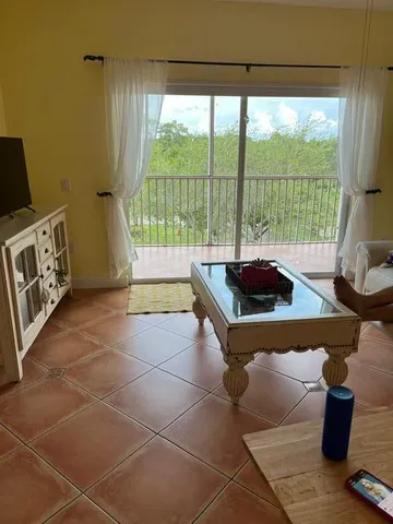 a living room with furniture and a floor to ceiling window