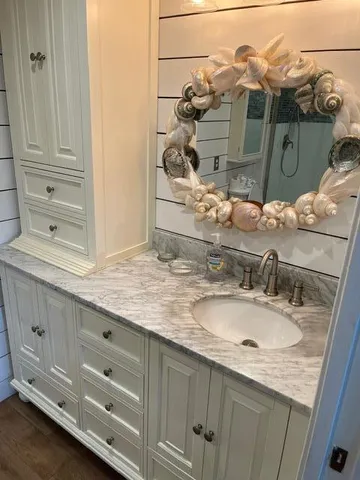 a bathroom with a granite countertop sink and mirror