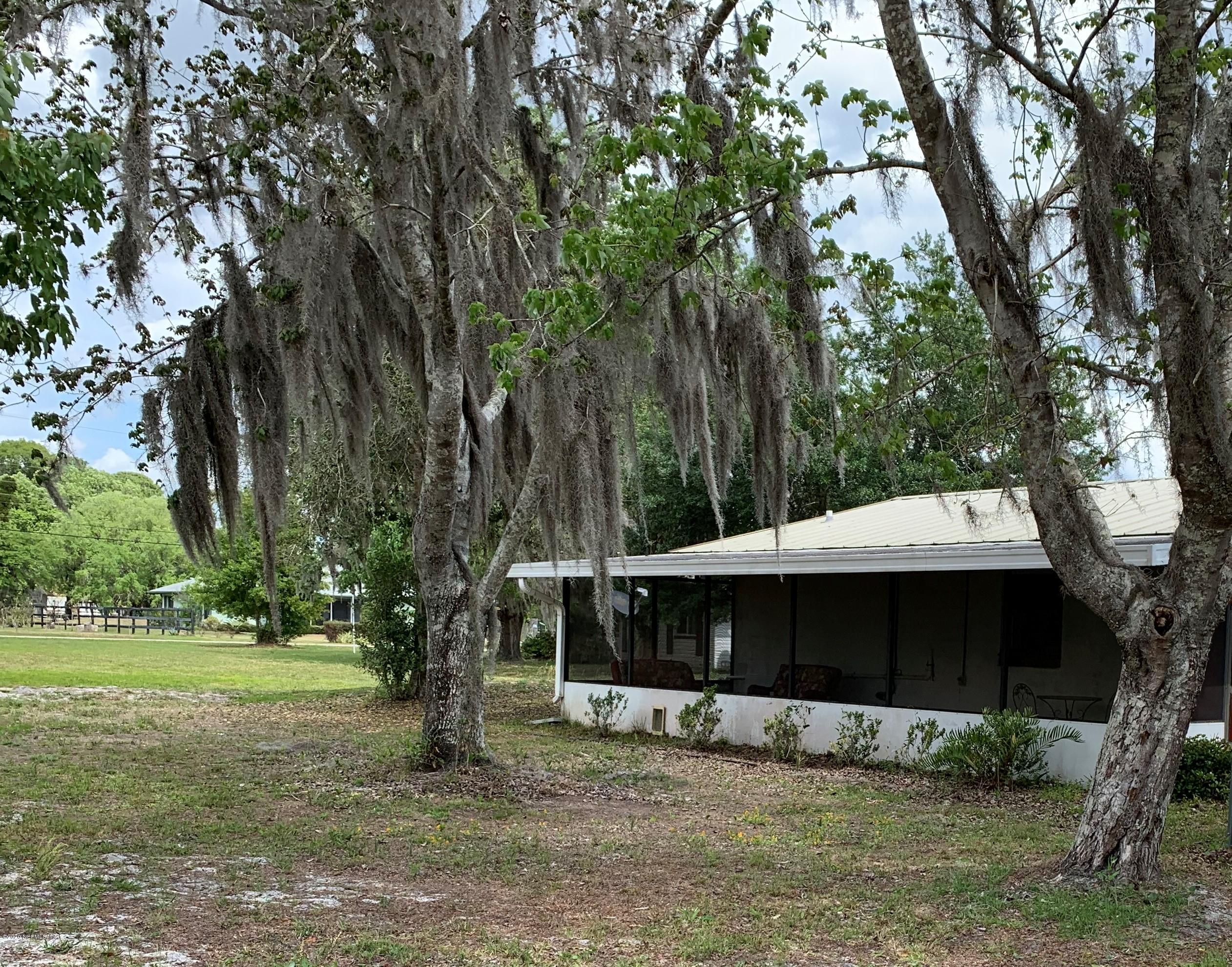 a view of a house with backyard and trees