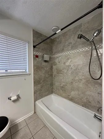 a bathroom with a granite countertop bathtub and a shower
