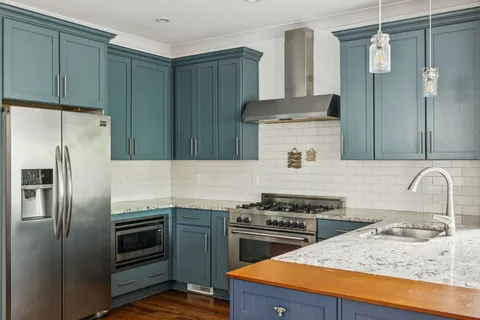 a kitchen with stainless steel appliances granite countertop a stove a refrigerator and a sink