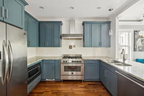 a kitchen with stainless steel appliances kitchen island a refrigerator sink and stove