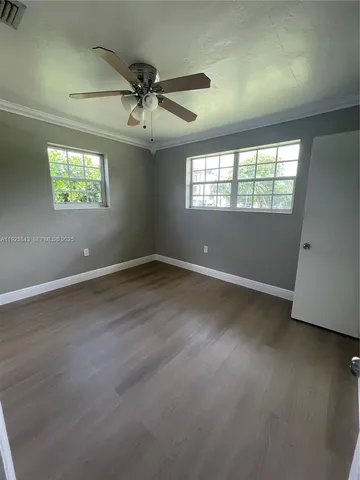 an empty room with a window and a ceiling fan