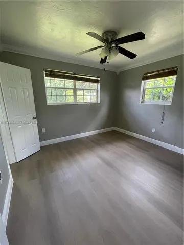 an empty room with windows and fan
