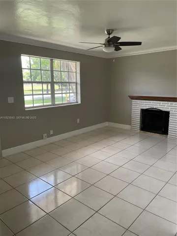 a view of an empty room with a fireplace and a window