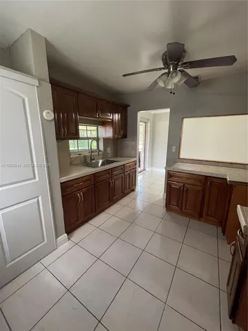 a large kitchen with granite countertop a refrigerator and a sink