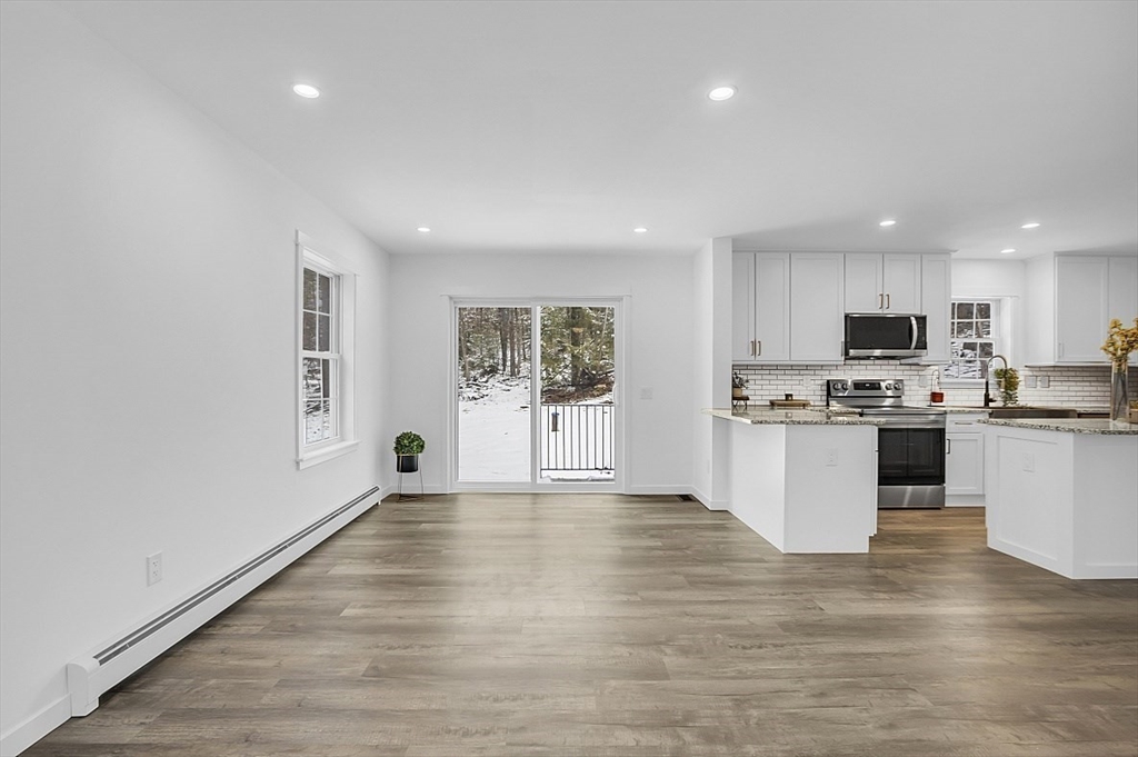 823 Carpenter Road Athol, MA 01331 - Photo 10 of 41 a large white kitchen with stainless steel appliances granite countertop a stove a sink dishwasher and a refrigerator with wooden floor