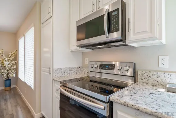 a kitchen with a granite countertop sink and potted plant