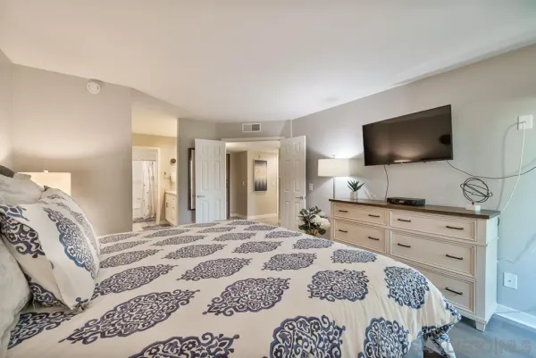 a bedroom with a bed and a flat screen tv