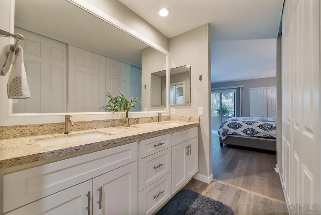 17637 Pomerado Road, Unit 123 San Diego, CA 92128 - Photo 22 of 61 a en suite bathroom with a granite countertop sink and a mirror