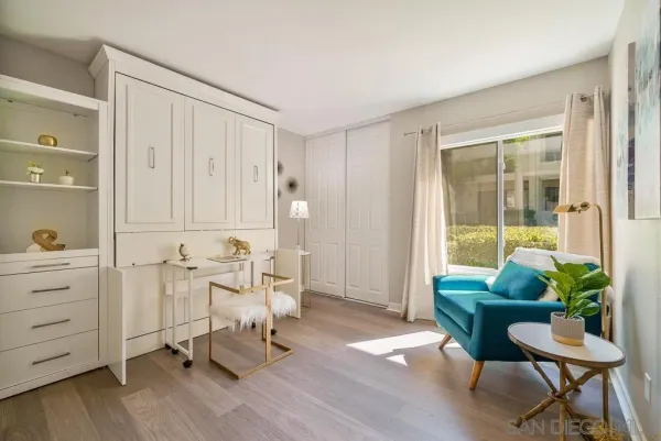 a room with table chair and white cabinet