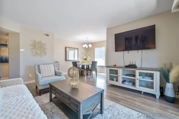 a view of a dining room with furniture a chandelier and wooden floor