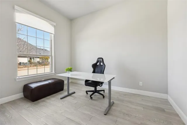 a view of a workspace with furniture and a window