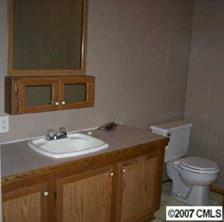 2515 Hinson Road Monroe, NC 28112 - Photo 3 of 8 a bathroom with a sink a toilet and a mirror