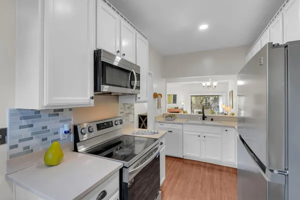 a kitchen with a sink a stove cabinets and counter space