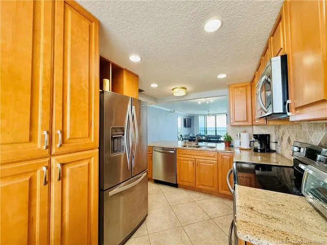 a kitchen with stainless steel appliances granite countertop a stove a sink and a refrigerator