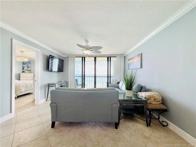 a living room with furniture kitchen view and a chandelier