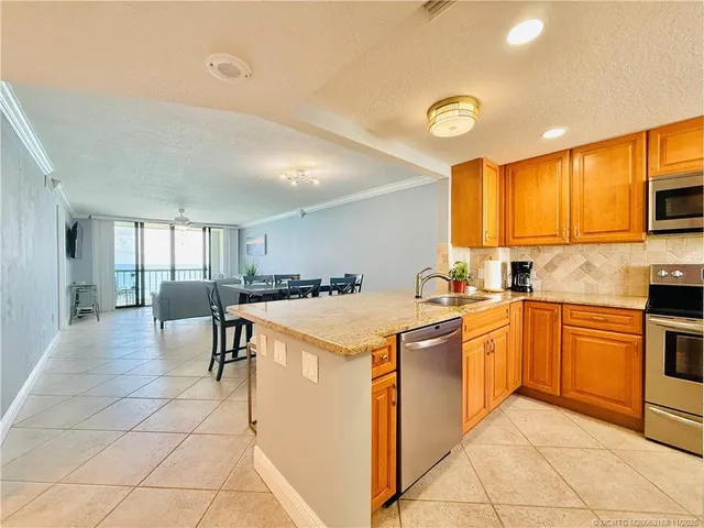 a kitchen with granite countertop a sink and stainless steel appliances
