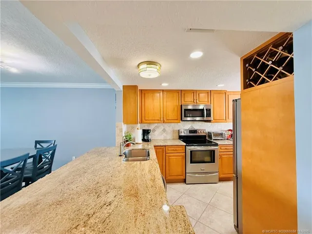 a kitchen with stainless steel appliances granite countertop a stove a sink and a microwave