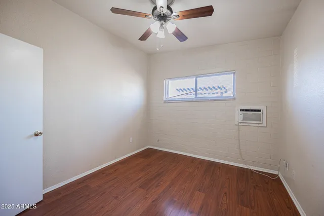 a view of a hallway with wooden floor and a chandelier fan