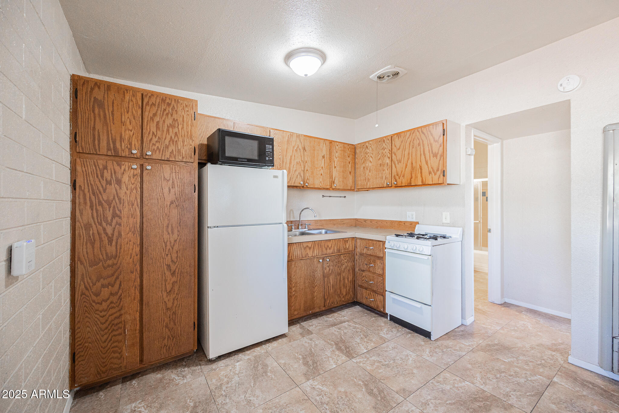 903 South Kenwood Circle, Unit 1 Tempe, AZ 85281 - Photo 10 of 15 a kitchen with a refrigerator sink stove and cabinets