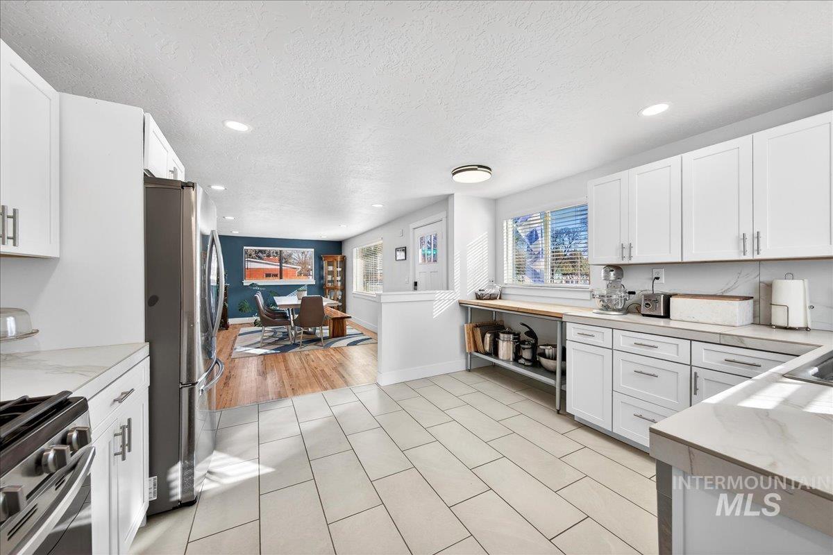 621 North Roosevelt Street Boise, ID 83706 - Photo 5 of 32 Kitchen featuring white cabinetry, recessed lighting, stainless steel appliances, and a textured ceiling