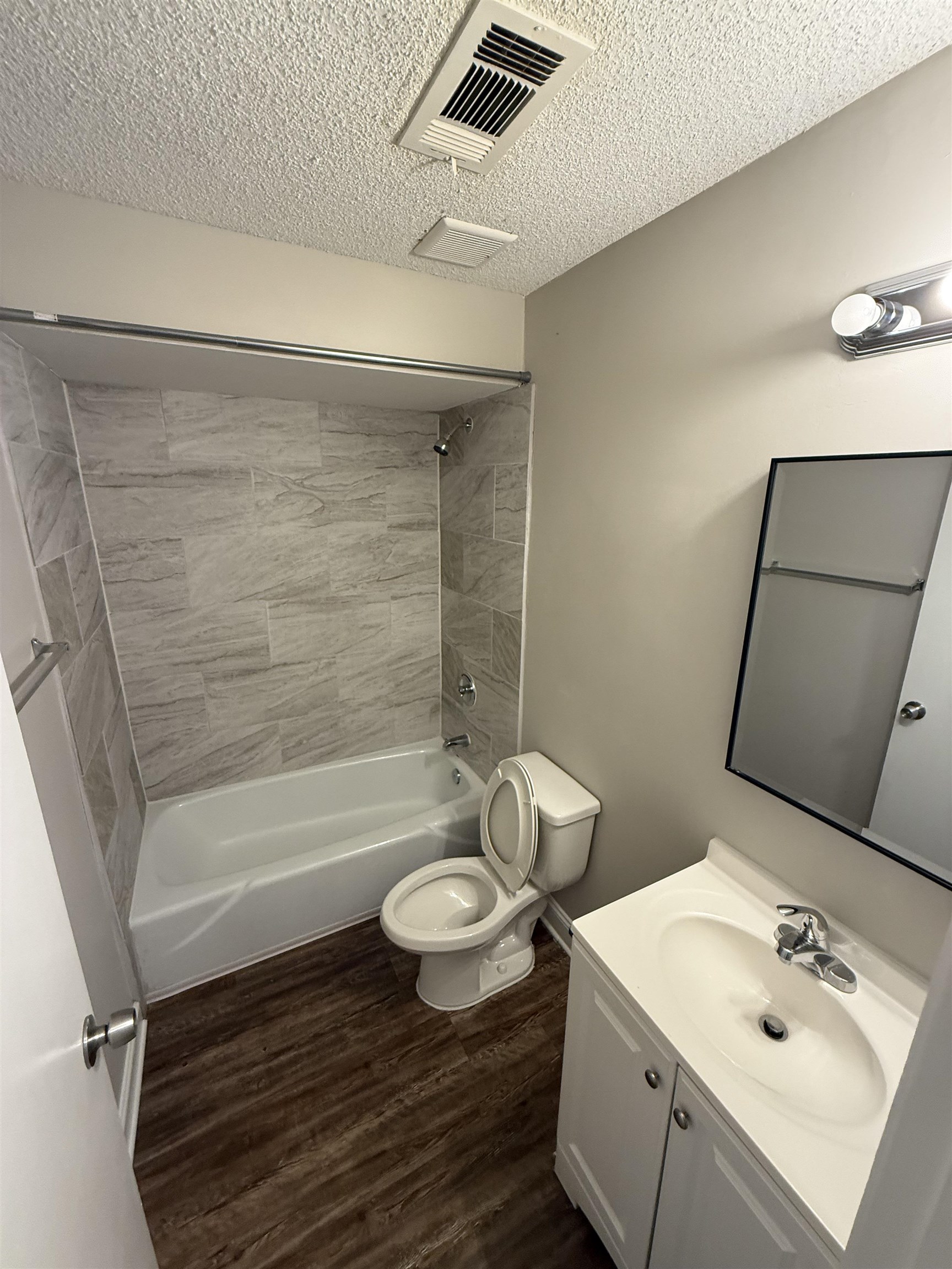 3016 Meadowfair Road Memphis, TN 38118 - Photo 11 of 17 Bathroom featuring a textured ceiling, vanity, washtub / shower combination, and wood finished floors