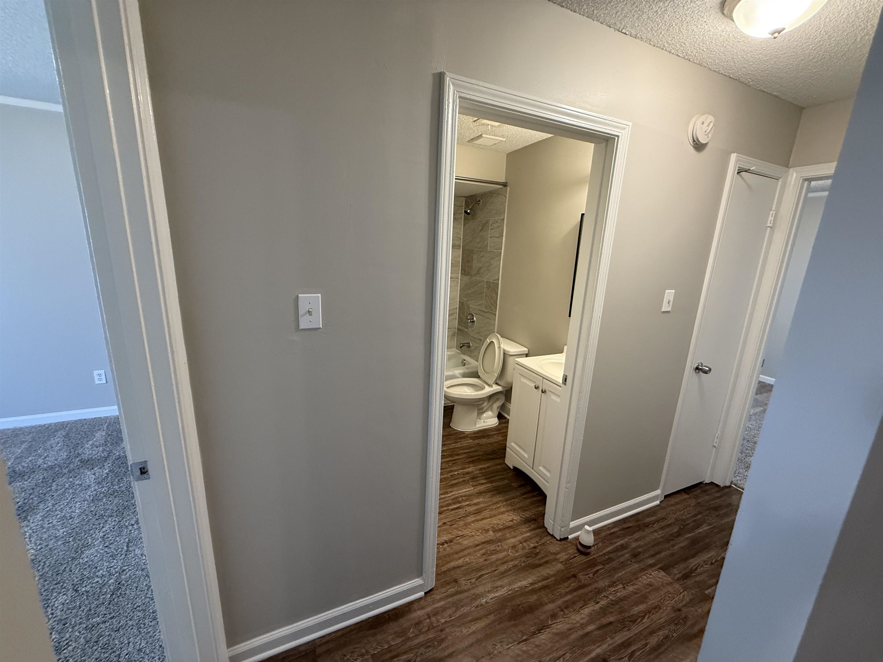 3016 Meadowfair Road Memphis, TN 38118 - Photo 14 of 17 Hallway featuring a textured ceiling and dark wood-style floors