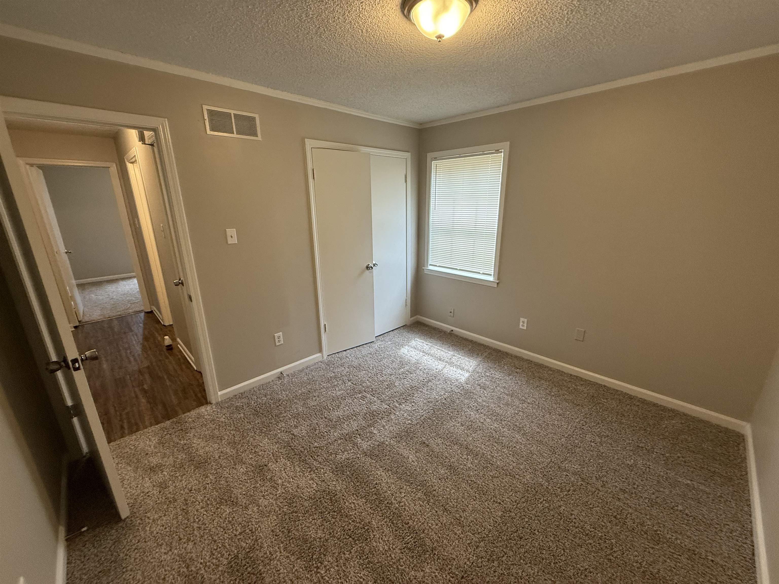 3016 Meadowfair Road Memphis, TN 38118 - Photo 8 of 17 Unfurnished bedroom with a textured ceiling, carpet floors, crown molding, and a closet