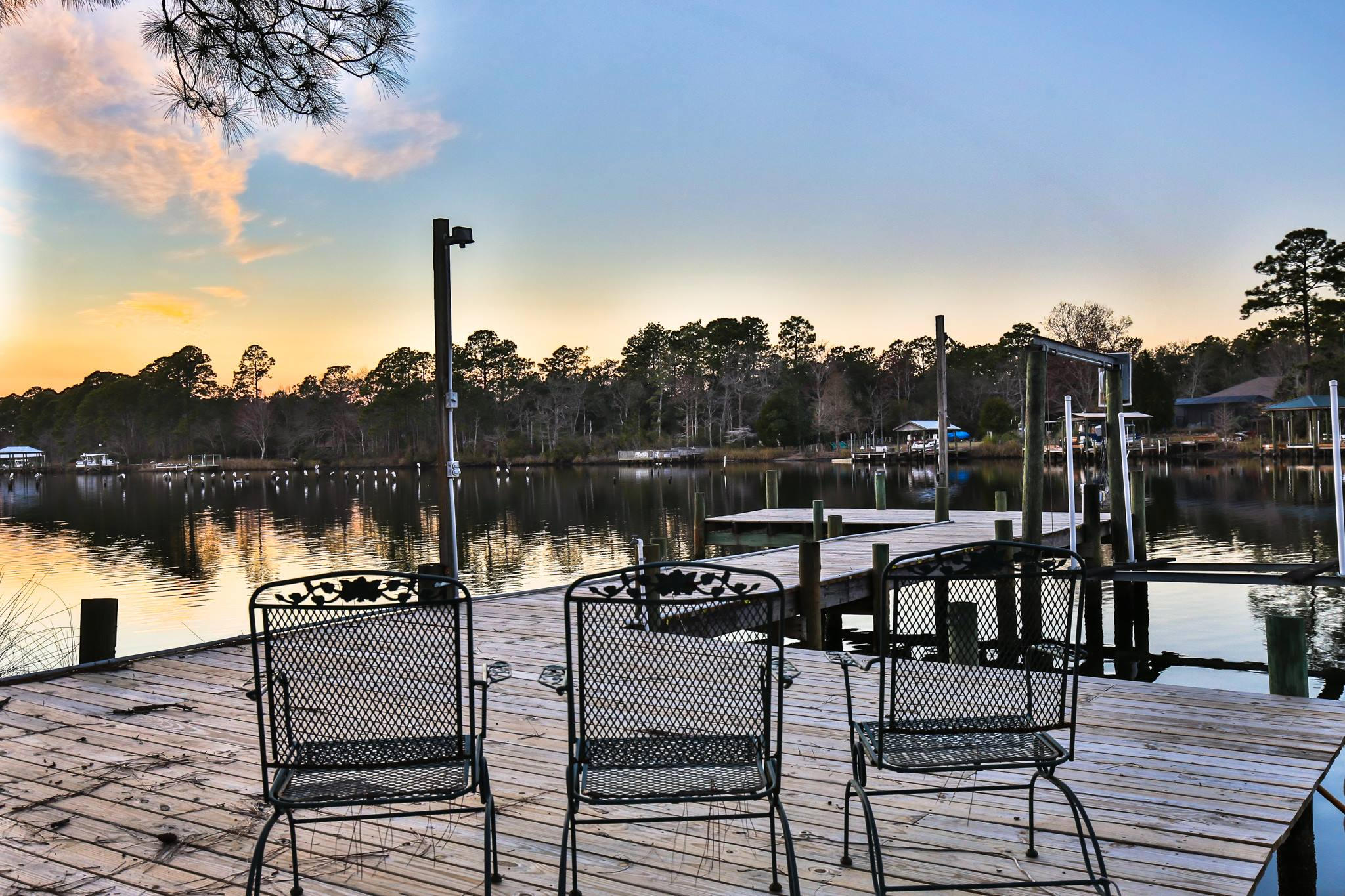 576 Mallet Bayou Road Freeport, FL 32439 - Photo 8 of 14 a view of a lake from a roof deck with table and chairs a barbeque with wooden floor and fence