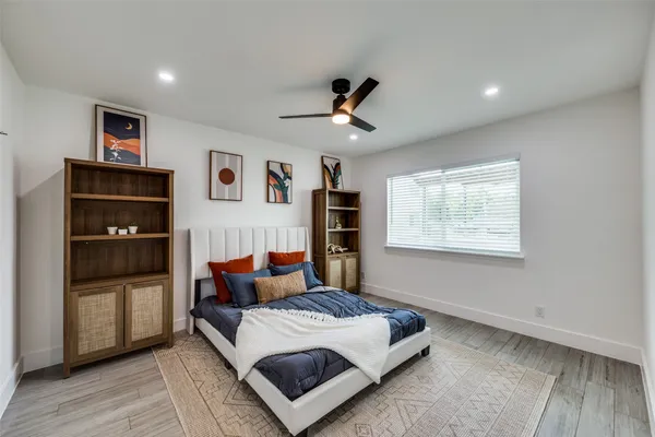 a bedroom with a bed and wooden floor