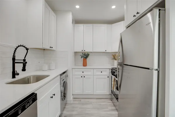 a kitchen with a refrigerator sink and cabinets