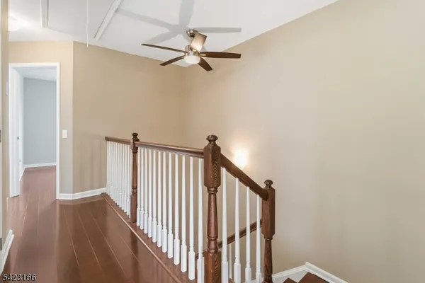 a view of a hallway with wooden floor and staircase