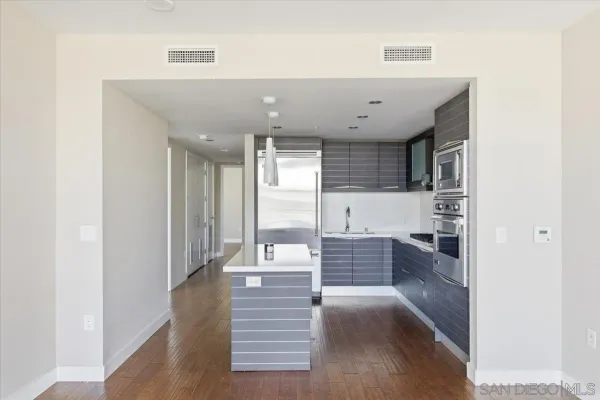 a kitchen with granite countertop a refrigerator and a stove top oven