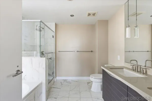 a bathroom with a granite countertop sink toilet and shower