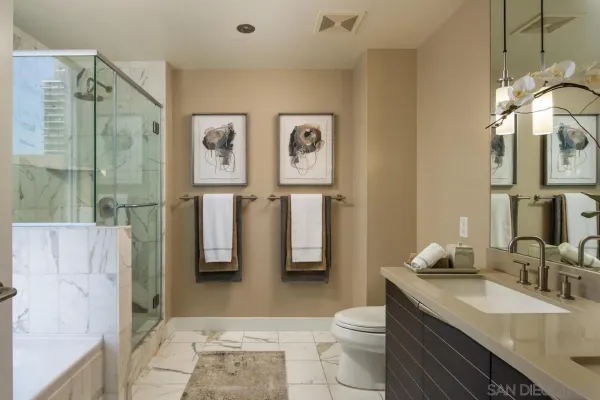 a bathroom with a granite countertop sink toilet and shower
