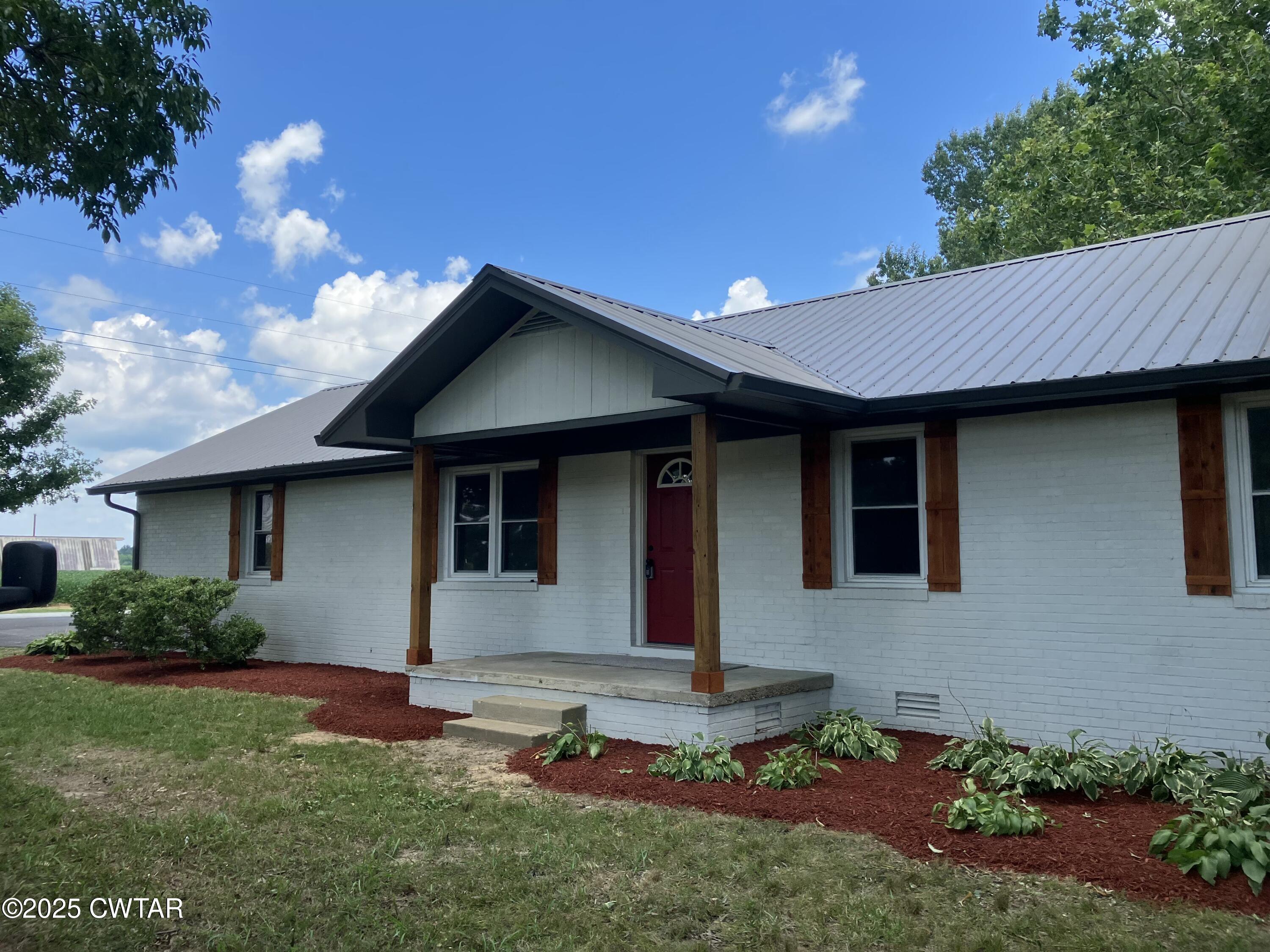 649 Spring Creek Law Road Jackson, TN 38305 - Photo 1 of 20 a front view of a house with a yard and garage