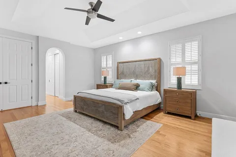 a bedroom with a large bed and ceiling fan