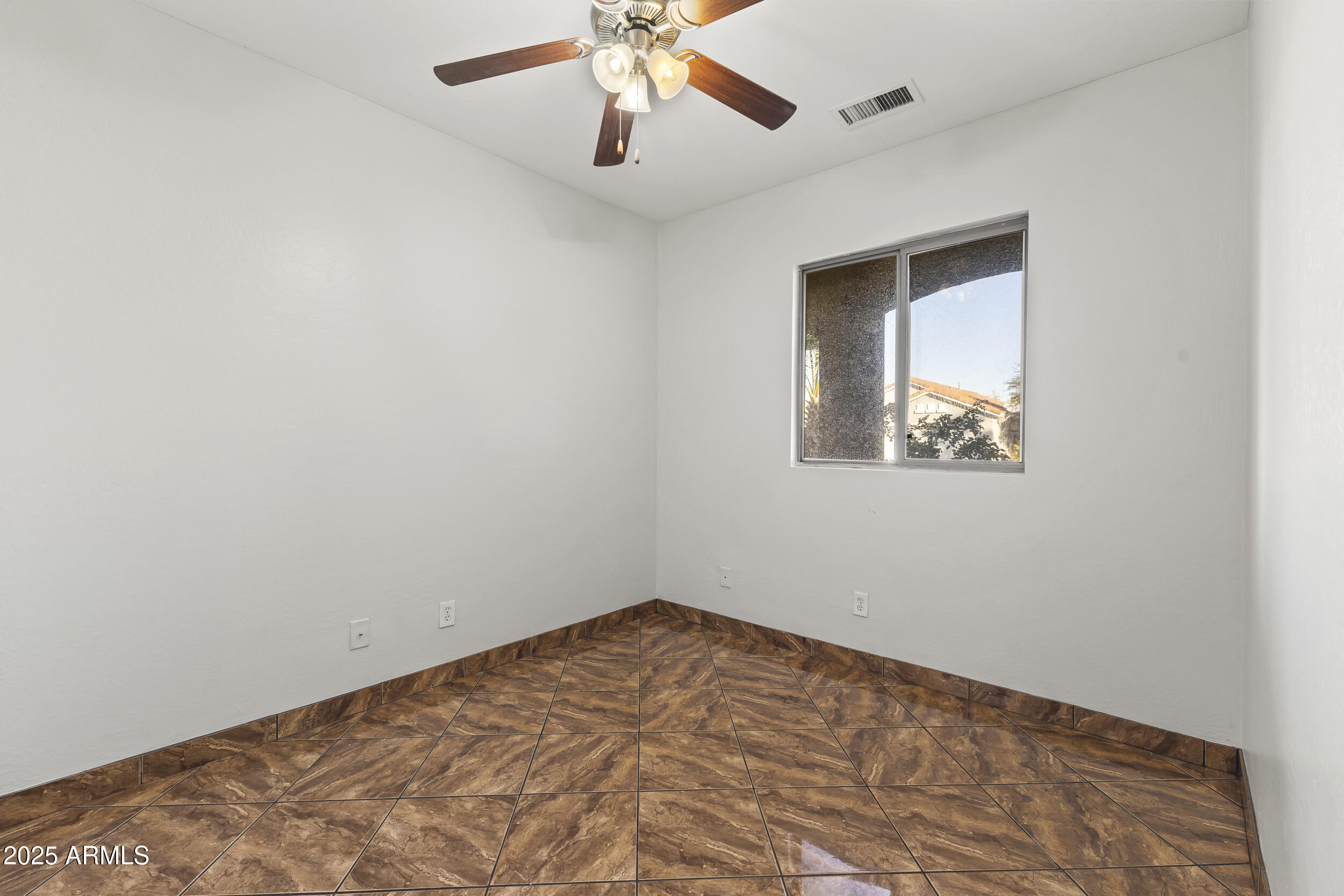 11185 West Coronado Road Avondale, AZ 85392 - Photo 13 of 46 an empty room with a window and a ceiling fan