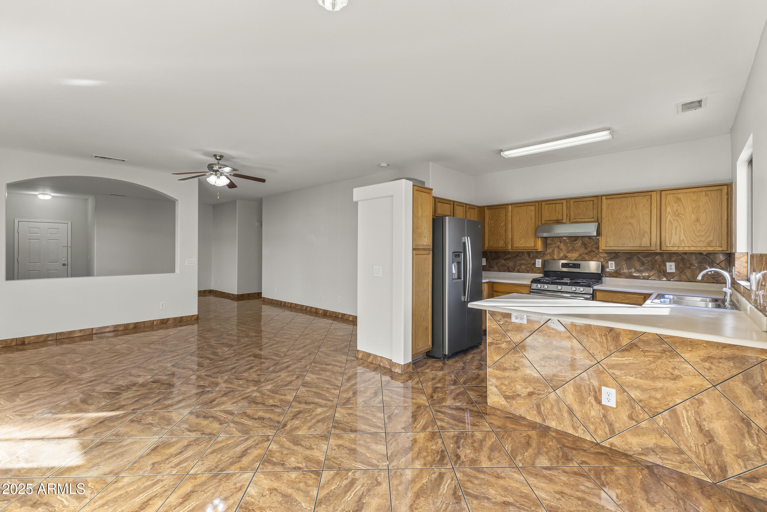 11185 West Coronado Road Avondale, AZ 85392 - Photo 24 of 46 a view of a kitchen with kitchen island a counter top space a sink and cabinets