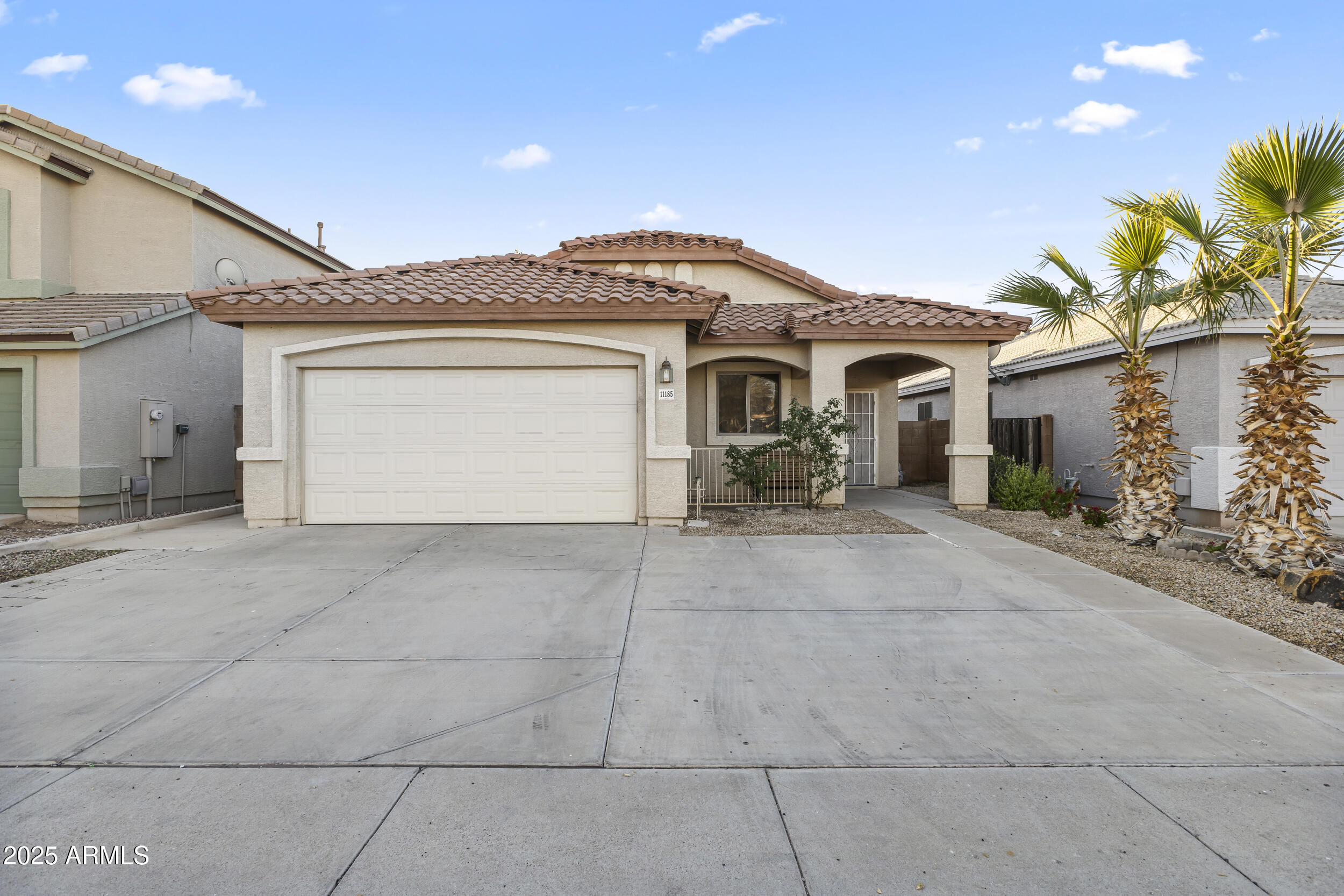 11185 West Coronado Road Avondale, AZ 85392 - Photo 2 of 46 a front view of a house with a garden and a garage