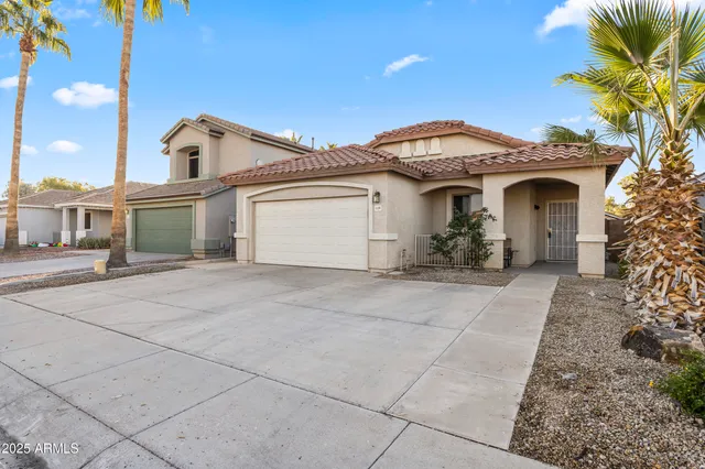 a front view of a house with a garden and a garage