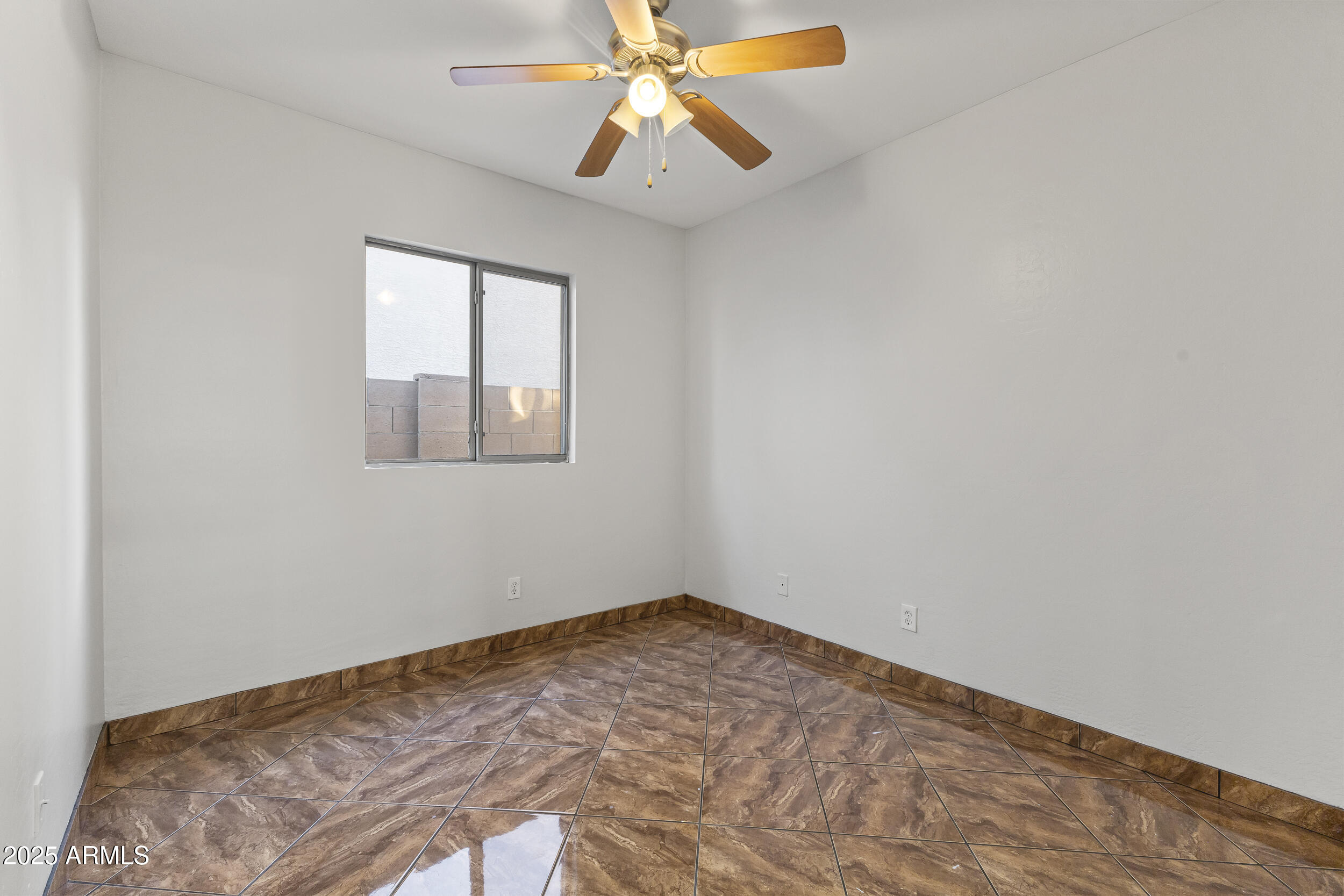 11185 West Coronado Road Avondale, AZ 85392 - Photo 8 of 46 an empty room with chandelier fan and windows