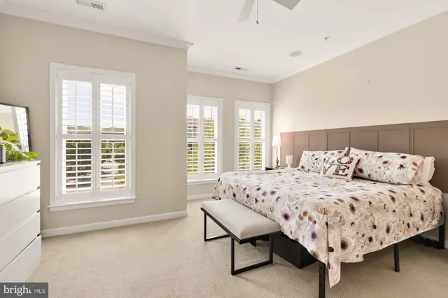 a bed sitting in a spacious bedroom next to a window