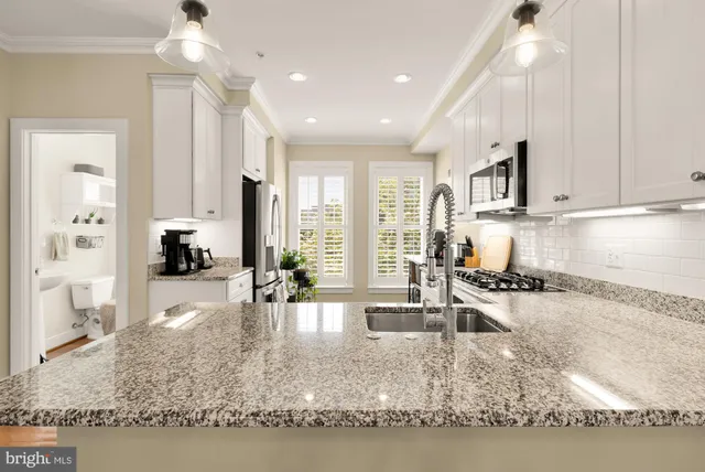 a kitchen with sink refrigerator and cabinets